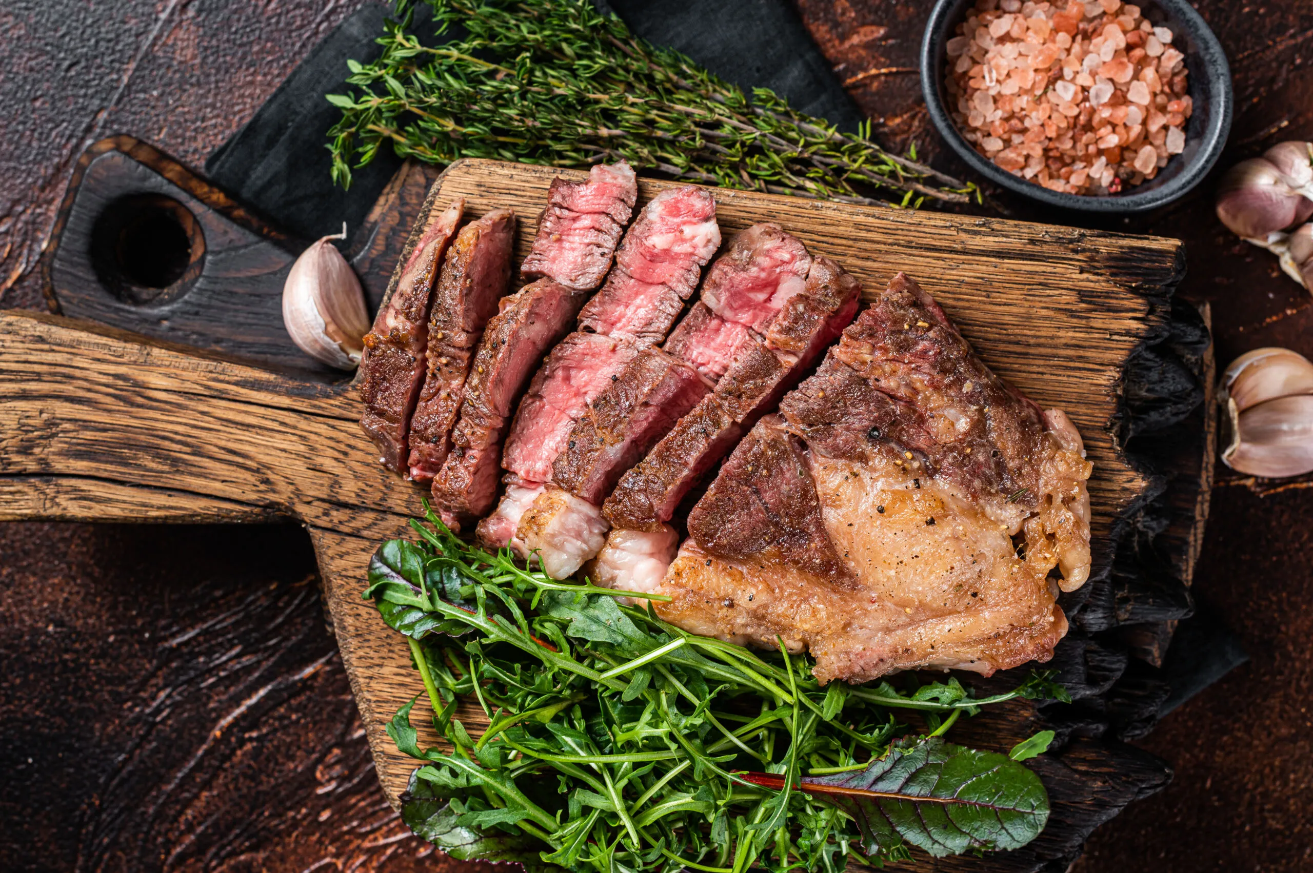 Grilled Chuck Roll beef steak with salad on wooden board. Speisekarte